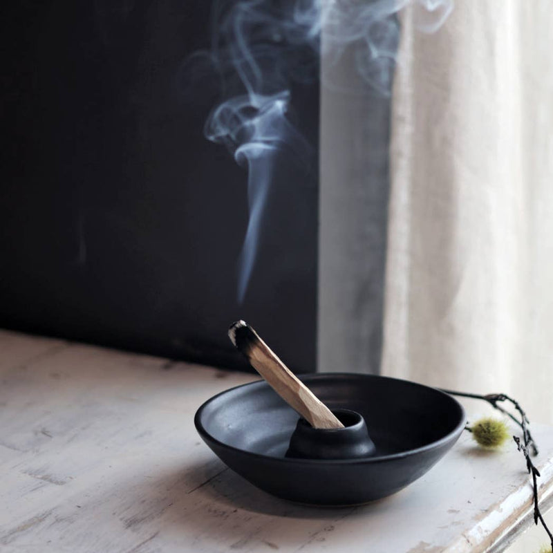 Gravesco Pottery - Palo Santo Burning Ritual Dish: Black, featuring a smoldering stick of aromatic wood, elegantly crafted for mindful rituals, capturing ash in its wheel-thrown, matte-black ceramic form.