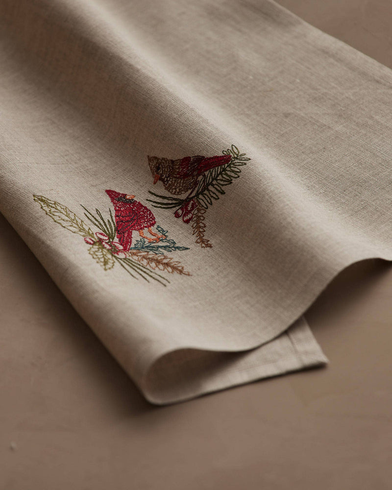 Coral & Tusk - Christmas Cardinals Tea Towel with embroidered cardinals on pine branches, folded, ideal for gifting, from Athens Cooks' curated kitchen collection.