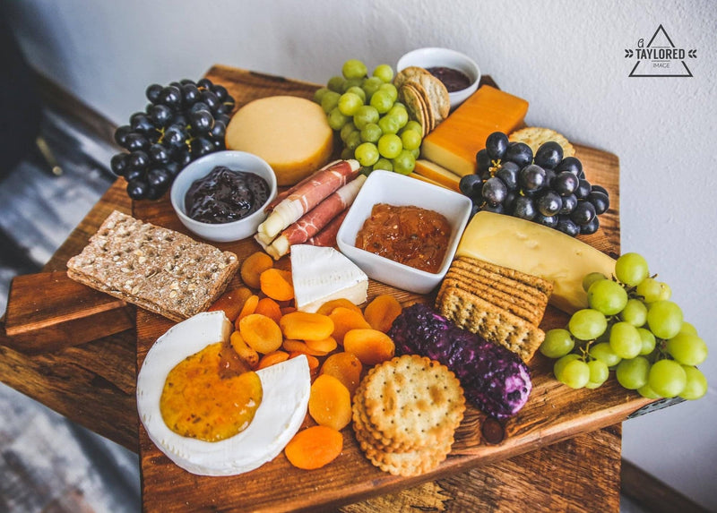 Cheese board featuring Southern Roots Sisters - Blackberry Pepper Jam, paired with assorted cheeses, meats, grapes, and crackers, ideal for enhancing charcuterie platters.
