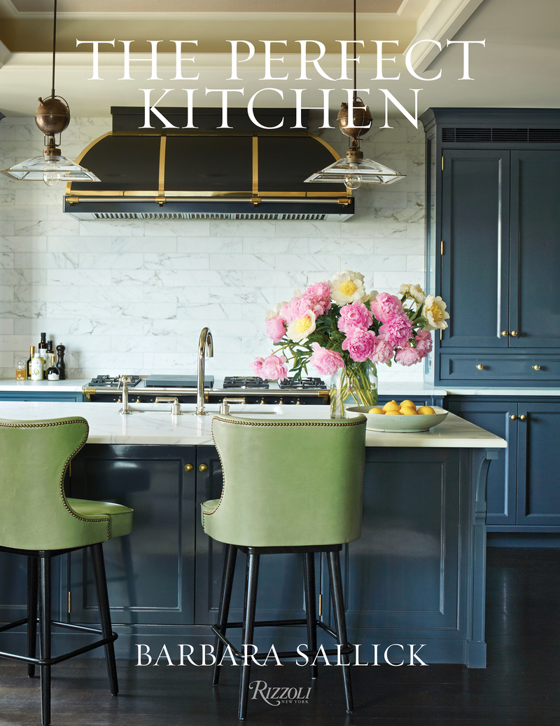 The Perfect Kitchen book cover featuring a stylish navy and brass kitchen with marble accents, green stools, pink peonies, and lemons, by Barbara Sallick.