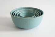 RachaelPots | Set of Three Nesting Bowls - Robin's Egg Blue, showcases hand-thrown, speckled turquoise ceramic bowls, skillfully nested, ideal for versatile kitchen use.