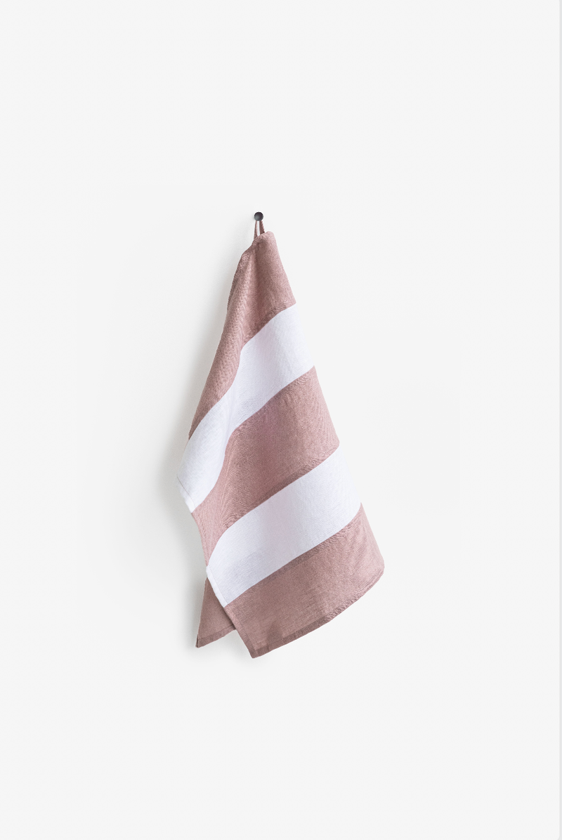 Striped linen tea towel on a hook, showcasing its hanging loop and eco-friendly design. Part of a zero-waste program, ideal for stylish kitchen utility.