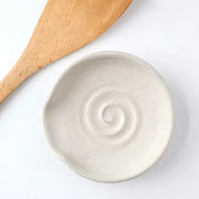 Gravesco Pottery handmade ceramic spoon rest, featuring a spiral relief, ideal for kitchen use. Includes a wooden spatula. Perfect for holding utensils while cooking.