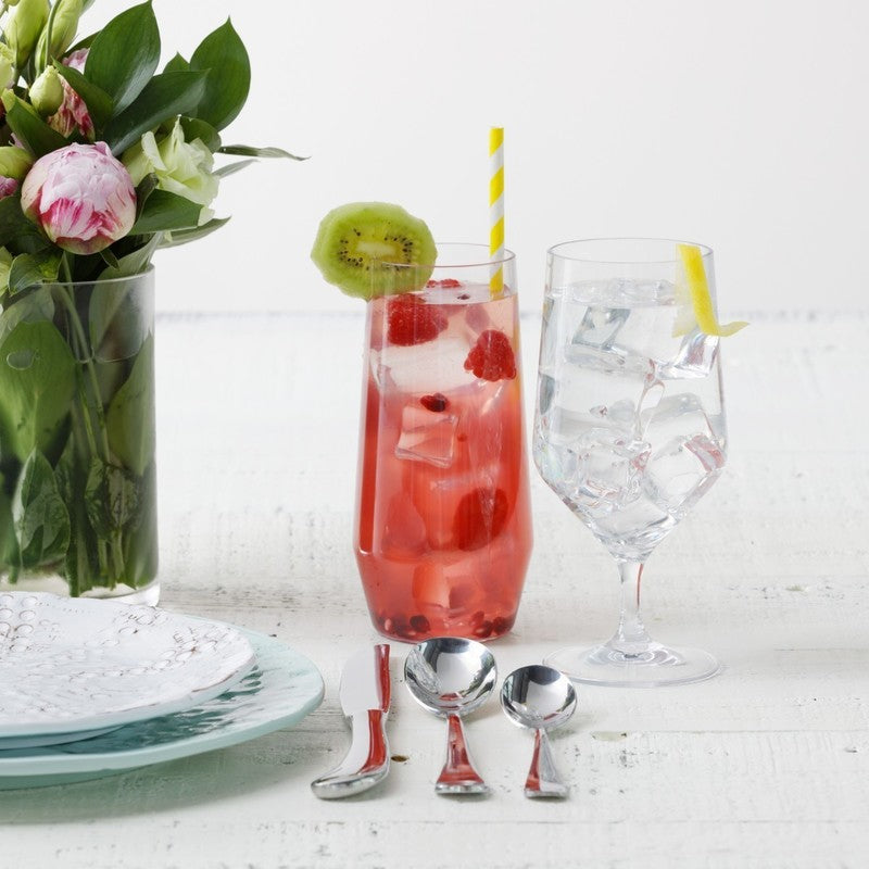 Zwiesel Fortessa | Tritan Outdoor Iced Tea Tumbler featured on a summery table with pink blooms, flatware, and refreshing drinks, ideal for outdoor dining.