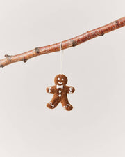 Farmhouse Pottery - Felted Gingerbread Ornament: Lady, handcrafted in Nepal, hangs from a branch. Made of 100% wool with detailed white icing features.