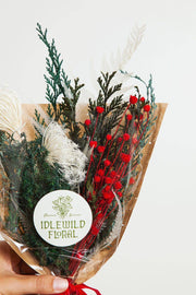 Idlewild Floral Co. - Christmas Mini Market Bouquet features dried conifer, red buds, and white ferns, wrapped in kraft paper, offering timeless decorative beauty.