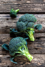 Two fresh broccoli heads and a floret on wood. Bentley Seed Co. - Broccoli-Green Sprouting 1800's, ideal for spring to fall planting, prolific garden essential.
