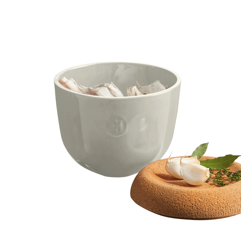 Emile Henry | Garlic Pot - Clay, featuring a ceramic bowl with ventilation holes for storing garlic, topped by a cork lid for optimal preservation.