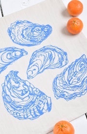Hearth and Harrow's Oyster Tea Towel in blue-violet, features an elegant oyster design on organic cotton, ideal for enhancing kitchen aesthetics and practical use.