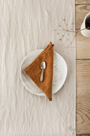 Set of 2 linen napkins from MagicLinen displayed on a plate with a spoon, showcasing their versatile use in table decor.
