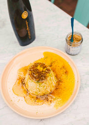 Villa Jerada - Dukkah - 50g in a glass jar with a blue spoon, alongside a creamy dessert and a bottle, ideal for enhancing dishes.