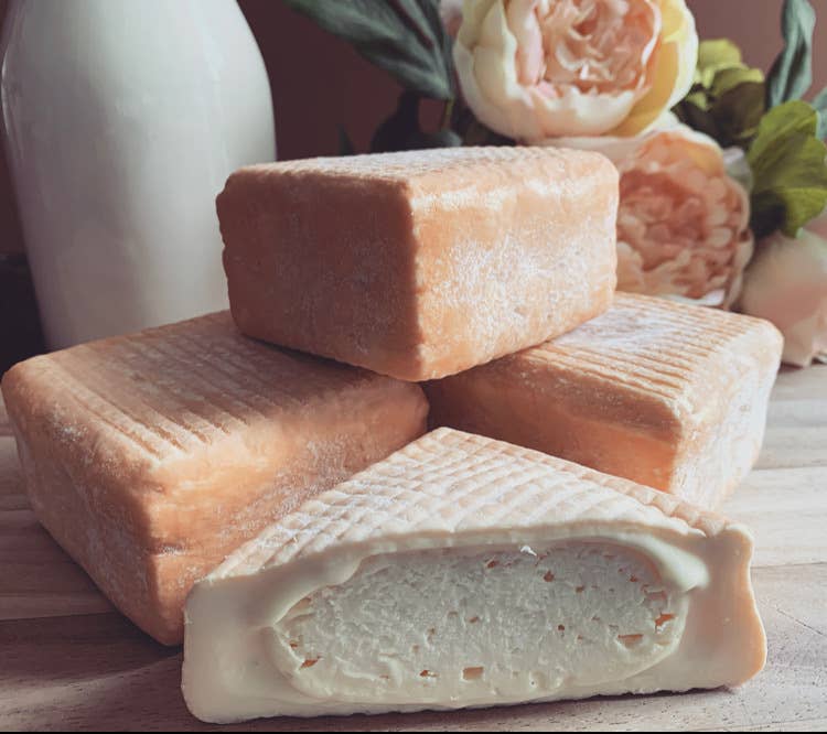Tulip Tree Creamery - Foxglove cheese, a Good Food Award Finalist, features a soft, scoopable texture and distinctive orange rind, displayed among other cheeses.