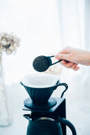 HARIO USA - V60 Metal Dripper with coffee grounds scoop, highlighting its precision brewing design for optimal coffee extraction.