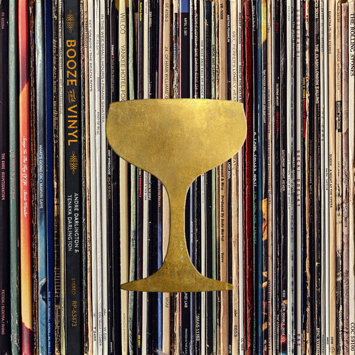 Booze & Vinyl: A guide to pairing cocktails with classic records, featuring a golden coupe glass over vinyl spines, perfect for music-themed gatherings.
