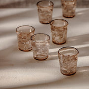 Zwiesel Fortessa Veranda Double Old Fashioned glass, 14oz, brown, crafted in rustic polycarbonate, filled with ice, casting soft shadows on a textured surface.