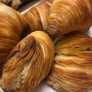 Nicola's Marketplace | Individual Mini Italian Sfogliatelle Pastries: Close-up of flaky, shell-shaped pastries filled with ricotta and orange peel, showcasing delicate, multi-layered crusts.