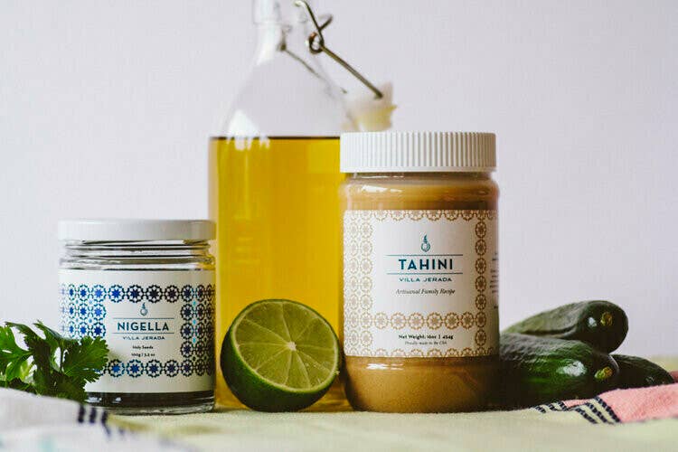 Villa Jerada - Nigella - 90g jar alongside tahini, oil, lime, herbs, and vegetables, ideal for crafting a Middle Eastern-inspired dip or dressing.