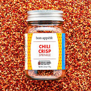 Burlap & Barrel - Chili Crisp Sprinkle, a 2.6 oz spice blend jar with dried chili flakes and crunchy bits, perfect for enhancing dishes with smoky-sweet flavor.