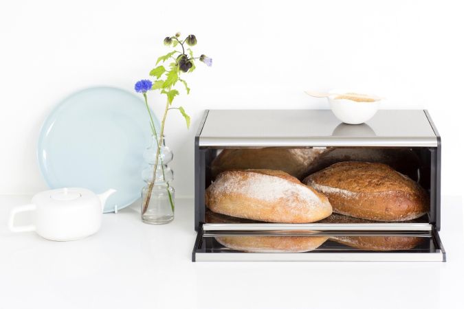 Brabantia USA Inc | Fall Front Bread Box Matt Steel in a kitchen setting, highlighting its space-saving design and easy access lid feature.
