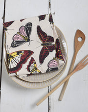 Hearth and Harrow - Butterfly Tea Towel - Organic Cotton - Oversized 30 x 30, folded on ribbed plates with wooden utensils, showcasing its elegant design.