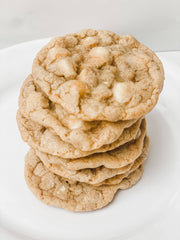 Southern Roots Sisters - White Chocolate Snickerdoodle Cookie Mix displayed as freshly-baked, golden-brown cookies with white chocolate chips on a white plate.