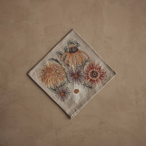 Coral & Tusk - Autumn Blossoms Dinner Napkin with embroidered fall flowers, including mums and daisies, on beige linen, ideal for seasonal dining at Athens Cooks.