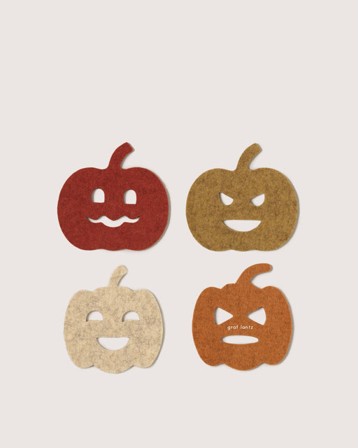 Graf Lantz - Merino Wool Pumpkin Coaster Multi 4 Pack arranged in a grid, showcasing festive jack-o’-lantern designs, perfect for protecting surfaces in stylish, sustainable fashion.