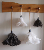 Earth & Nest | Feather Duster with premium feathers and a blond wood handle, displayed on a wall. Ideal for elegant and effective home cleaning.