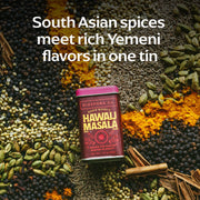 Diaspora Co. - Hawaij Masala Spice Blend tin surrounded by black peppercorns, cardamom, cumin, coriander, turmeric, cloves, and cinnamon, highlighting South Asian and Yemeni flavors.