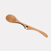 Jonathan's Cherry Wood Ladle from the Lazy Spoon® + Ladle Collection, designed for practicality and style, rests elegantly on a pot for mess-free serving.
