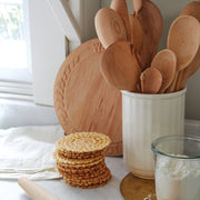 Sir|Madam Fluted Wall Crock on a sunlit countertop, holding wooden utensils, showcasing its versatility as both a utensil holder and charming decor piece.