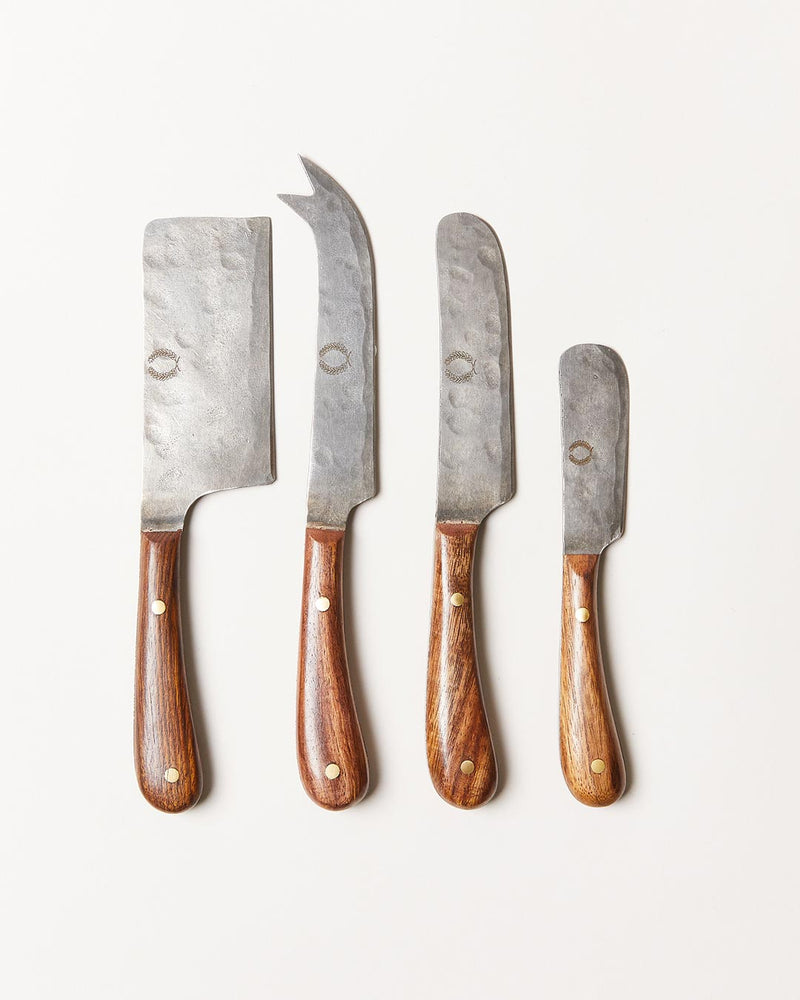 Farmhouse Pottery | Artisan Forged Cheese Knives set: four hand-hammered steel knives with wooden handles, including cleaver, carving, slicing, and paring knives, ideal for curated kitchen use.