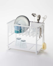 Yamazaki Home | Two-Tier Dish Rack - White, featuring a compact design with adjustable plastic drainer tray, utensil holder, and metal hooks for efficient kitchen organization.