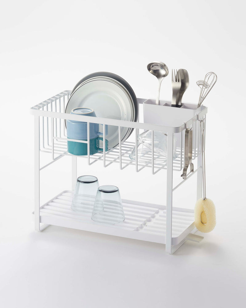 Yamazaki Home | Two-Tier Dish Rack - White, featuring a compact design with adjustable plastic drainer tray, utensil holder, and metal hooks for efficient kitchen organization.