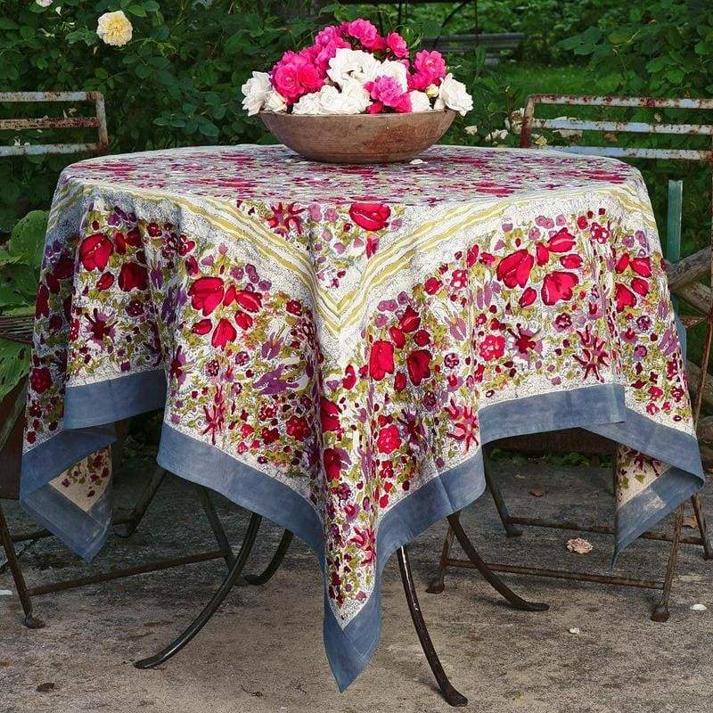Caravan Home 71 x 71 Red & Grey Tablecloth on a table with a bowl of flowers, showcasing French-inspired design, ideal for enhancing dining settings.