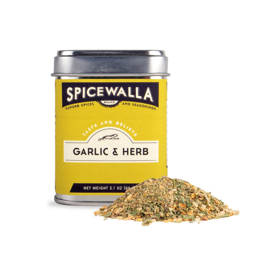 Spicewalla | Garlic & Herb seasoning tin with garlic-herb mix spilled in front, showcasing its zesty, herbaceous blend for versatile culinary uses.