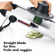 Person using the OXO Chef's Steel Mandoline to slice zucchini, showcasing its efficient design as a kitchen tool.