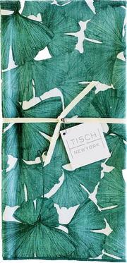 Tisch New York Floral Tea Towel with a white tag on green and white fabric, showcasing intricate detailing. Sold individually, pre-washed, and made in the USA.