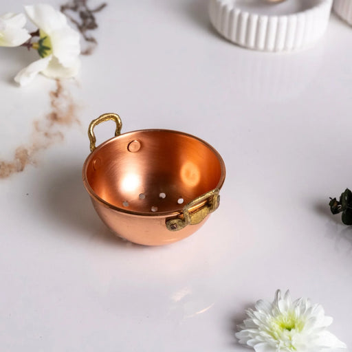 ALFIQ | Handmade Copper Miniature Kitchen Utensil Ornament, Colander with brass handles, set among white flowers, evokes nostalgic charm for kitchen decor.