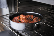 Hestan | NanoBond Cookware, 3.5qt Sauteuse on oven rack, braising chicken in tomato sauce with olives, showcasing its superior heat conduction and scratch-resistant surface.