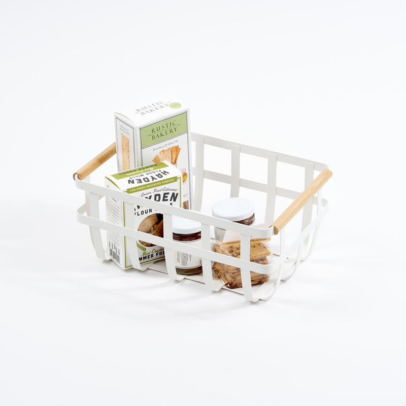 Yamazaki Home's large Steel + Wood Storage Basket holds an assortment of crackers and spreads, showcasing a stylish, organized snack presentation.