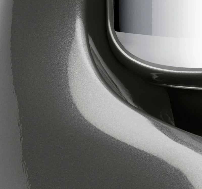 Close-up of Ankarsrum Stand Mixer, showcasing its smooth metal surface and glossy inset, highlighting the appliance's durable design and precision craftsmanship.