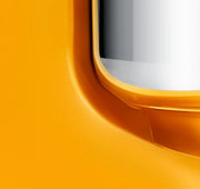 Close-up of Ankarsrum Stand Mixer’s bright orange housing with silvery trim, showcasing its sleek design and durable craftsmanship for home bakers.