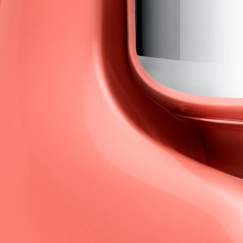 Close-up of a coral Apple Watch case, showcasing its sleek aluminum curve around the sensor, reflecting the precision of Ankarsrum stand mixers at Athens Cooks.