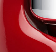 Close-up of the Ankarsrum Stand Mixer in red, featuring its rounded body and silvery visor, ideal for heavy doughs with a 7-liter bowl.