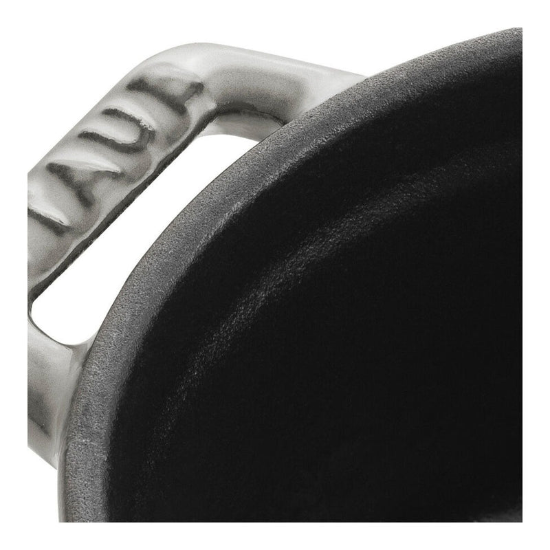 Staub Mini Round Dutch Oven in graphite, 0.275 QT, close-up showing enameled cast iron rim and handle, ideal for single-serve culinary creations.