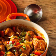 Le Creuset Signature Round Wide Oven with stew, matching lid, and ladle; perfect for crafting flavorful meals at Athens Cooks.