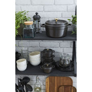 Staub Mini Round Dutch Oven, Black, 0.275 QT, sits on open kitchen shelving with Staub bowls, cocottes, and cookware, showcasing Athens Cooks' curated kitchen collection.