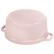 Staub | Round Dutch Oven, Pink Peony, 5.5 QT., shown upside-down with two side handles, showcasing its sturdy cast-iron construction.