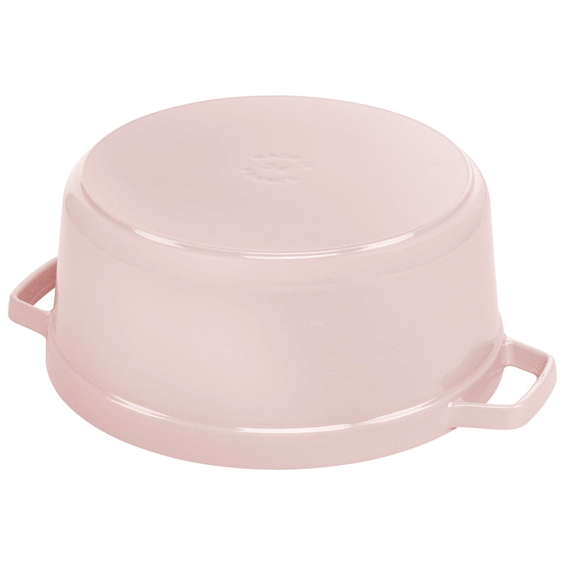 Staub | Round Dutch Oven, Pink Peony, 5.5 QT., shown upside-down with two side handles, showcasing its sturdy cast-iron construction.